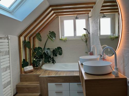 a bathroom with two sinks and a bath tub at Parenthèse de rêve - Piscine & confort au Mans in Coulaines