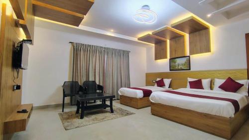 a hotel room with two beds and a television at ST Kodai Heaven Stay in Kodaikānāl