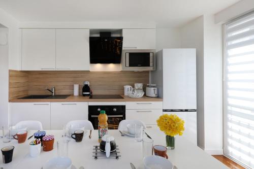 a kitchen with a table with chairs and a refrigerator at Le Manalac votre Appartement 4-6P au centre ville in Gérardmer