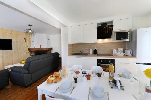 un salon avec une table blanche et un canapé dans l'établissement Le Manalac votre Appartement 4-6P au centre ville, à Gérardmer