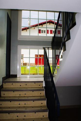 - un escalier dans un bâtiment doté d'une grande fenêtre dans l'établissement Chamant 3 rooms of 63 m2 in Saint-Jean-de-Luz, à Saint-Jean-de-Luz