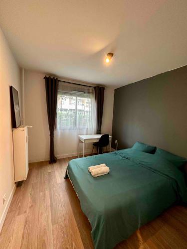 - une chambre avec un lit vert et un bureau dans l'établissement Appartement spacieux aux portes du Vieux-Lille, à La Madeleine