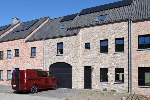 a red van parked in front of a brick building at luxurious home in Oud-Turnhout