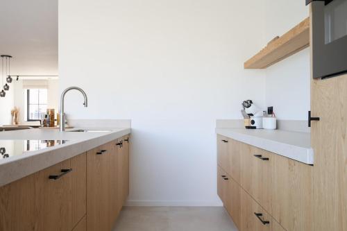a kitchen with wooden cabinets and a sink at luxurious home in Oud-Turnhout