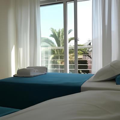 a bedroom with two beds and a large window at Casa da Vinha in Viana do Castelo