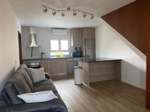 a living room with a couch and a kitchen at Casa Candido in Aboim