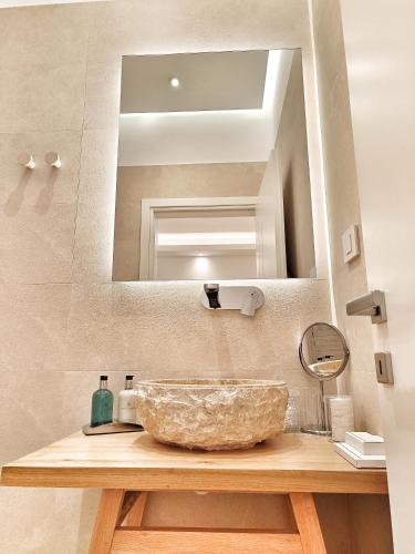 a bathroom with a bowl sink and a mirror at DelMar Suites Syros in Finikas