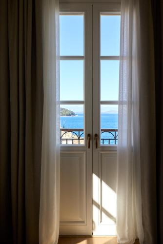 an open window with a view of the ocean at The Calliston in Corfu Town