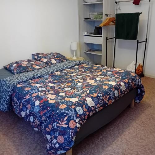 une chambre avec un lit avec une couette fleurie dans l'établissement Clos A Malypense chez Mr Montamat, à Galan