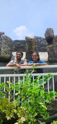 a man and a woman standing behind a fence at S & B Dreams House in Munnar