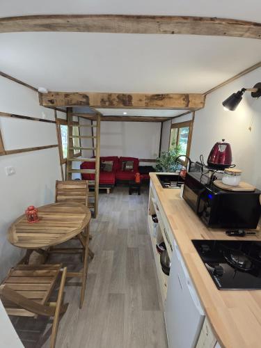 a kitchen and living room with a stove and chairs at Le Coeur De La Foret in Pierrefonds
