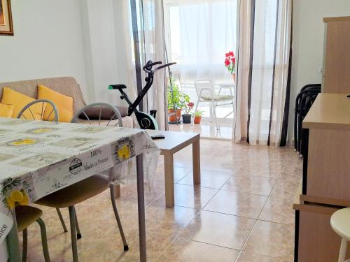 un salon avec une table et une pièce avec un vélo dans l'établissement Corinto, à Benalmádena