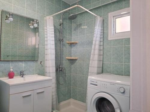 une salle de bain avec douche et machine à laver dans l'établissement Corinto, à Benalmádena