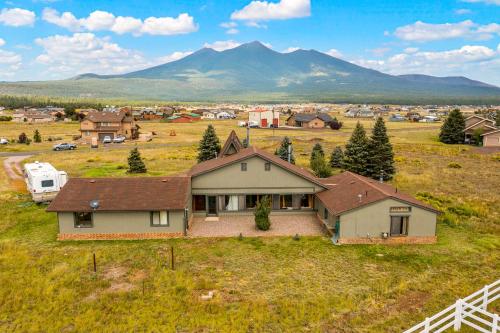 a house in a field with a mountain in the background at Rustic Mountain Chalet with Private Studio Minutes from Snowbowl in Flagstaff