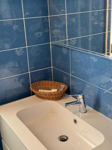 a bathroom with a sink and blue tiled walls at B&B Panorama in Zapponeta