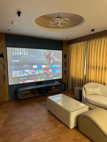 a living room with a large tv and a couch at Hotel victoria prime in Surat