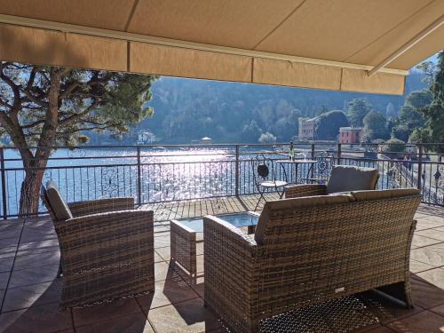 a balcony with chairs and a table and a view at Il Golfo Apartment, Lenno in Lenno