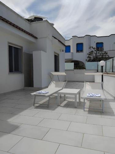 a patio with two benches and a building at Villa Incanto Pina - Torre Canne in Torre Canne