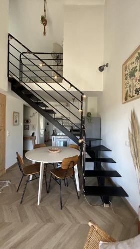 une salle à manger avec une table et un escalier en colimaçon dans l'établissement Duplex avec vue sur les Alpilles, à Saint-Rémy-de-Provence