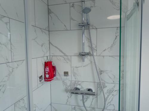 a shower with a red phone on a wall at Ideal Studio Loft 30min to Central London in London