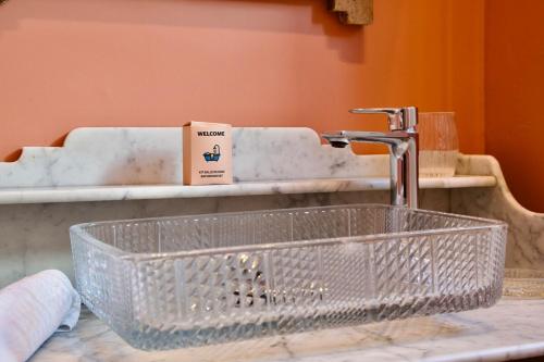 un lavabo de salle de bain avec un plan de travail en verre transparent dans l'établissement Grand appartement 6 voyageurs, à Lille