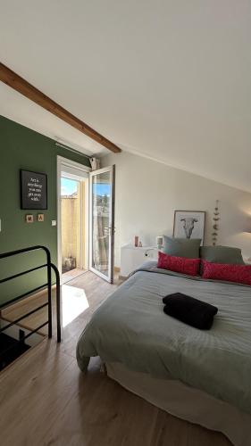 une chambre avec un grand lit aux murs verts dans l'établissement Duplex avec vue sur les Alpilles, à Saint-Rémy-de-Provence