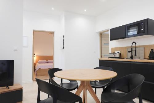 une cuisine et une salle à manger avec une table et des chaises dans l'établissement La Glycine, à Aigues-Vives