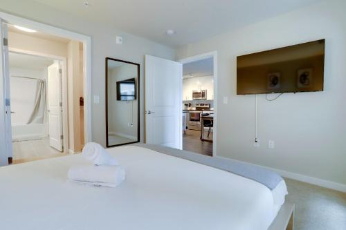 a white bedroom with a large white bed and a mirror at Spacious Stay in Alexandria Easy Access to DC in Alexandria