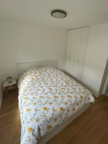 une chambre avec un lit avec une couette fleurie dans l'établissement Appartement 2 Pièces Rénové avec Terrasse et Garage, à Cannes