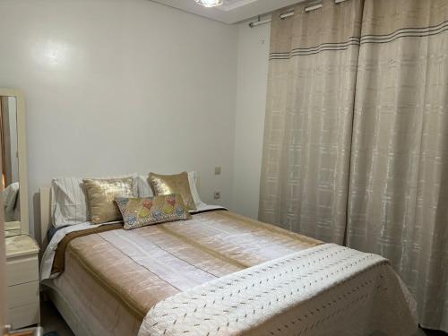 ein Schlafzimmer mit einem großen Bett mit einem Vorhang in der Unterkunft Modern 2-room with pool, close to beach, private parking in Martil