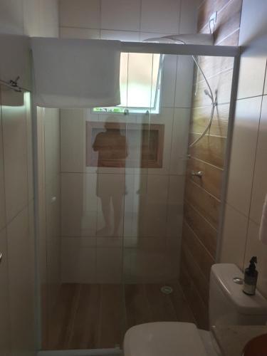 a bathroom with a shower with a toilet and a window at Chalé Canto da Montanha in São José dos Campos