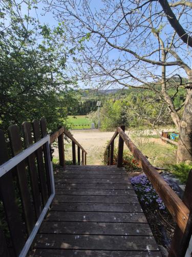 a wooden boardwalk leading to a field with a fence at Hereczówka in Laskówka