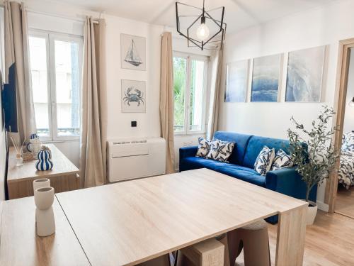 un salon avec un canapé bleu et une table dans l'établissement Suite Palmiers bleus Cannes, à Cannes
