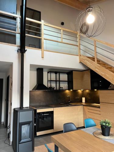 une cuisine et une salle à manger avec un poêle et une mezzanine dans l'établissement Maisons de vacances Carol, à Latour-de-Carol