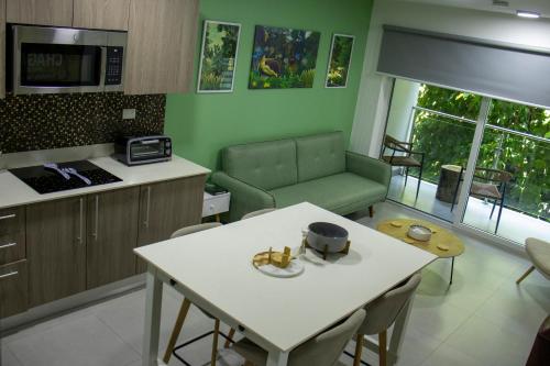 a kitchen and living room with a table and a couch at Punta Esmeralda by Punta Leona in Jacó