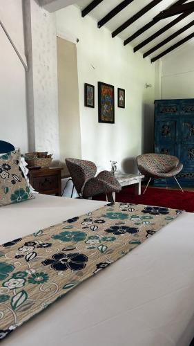 a bedroom with a bed and two chairs and a table at Villa Juana Hotel in Pereira
