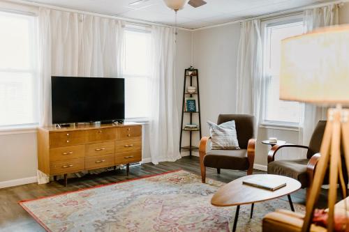 a living room with a flat screen tv on a dresser at Spacious Home Near Lake MI w Fire Pit in Sheboygan