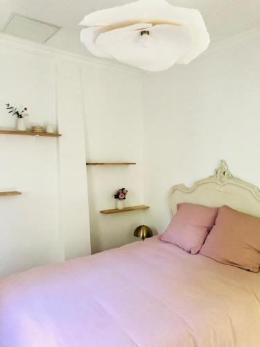 - une chambre avec un lit rose et un lustre dans l'établissement Villa Mini Romy with outdoor area, à Parmain