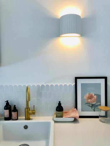 une salle de bain avec un lavabo, une lampe et un tableau dans l'établissement Villa Mini Romy with outdoor area, à Parmain
