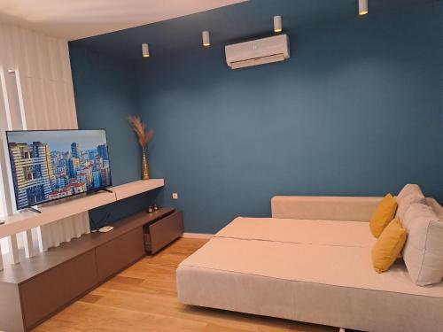 sypialnia z łóżkiem i niebieską ścianą w obiekcie Centar Apartment w mieście Skopje