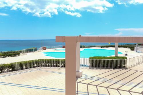 - une vue sur la piscine et l'océan en arrière-plan dans l'établissement Appartement Piscine Front de mer 43 m2, Sète, à Sète