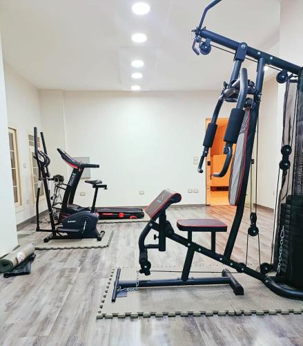 a gym with several treadmills and exercise bikes at My Villa Hotel in Sheikh Zayed