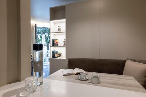 a table with a book and a bottle and a glass at Residence Oliveto in Ceriale