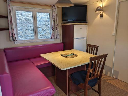 un salon avec une table et un canapé dans l'établissement Mobil-home, à Arconcey