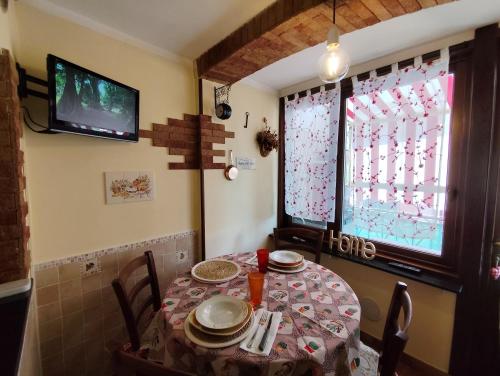a dining room with a table and a tv at La casa del pittore con climatizzatore Pieve di Teco centro in Pieve di Teco