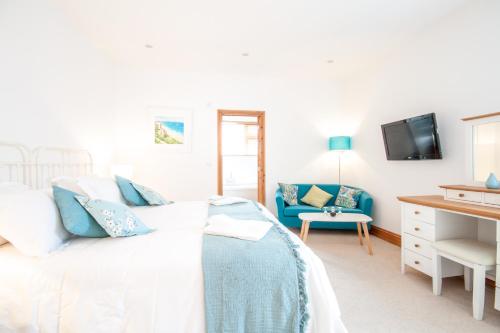 sypialnia z łóżkiem i niebieską kanapą w obiekcie Padstow Bed & Breakfast w mieście Padstow
