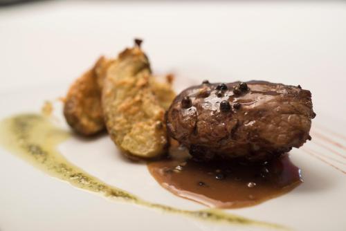 a piece of food on a white plate with sauce at Ville Saint Germain Apart Hotel & Spa in Carilo