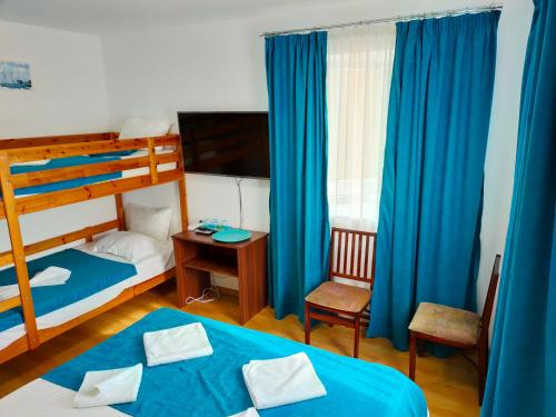 a bedroom with two bunk beds and blue curtains at Casa BEYAZ in Mangalia