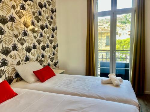 une chambre avec deux lits blancs et une fenêtre dans l'établissement Le Splendide YourHostHelper, à Nice
