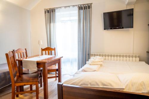 a bedroom with a bed and a desk and a television at Pokoje Gościnne Na Szlaku in Krościenko